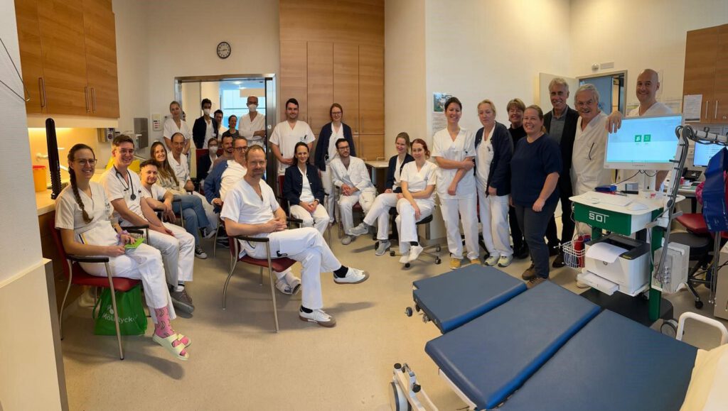 Group photo of the medical team at Landesklinikum Melk and representatives of SOT Medical Systems during a device training session. In the foreground: the AngE™ system mounted on a SOT trolley for vascular diagnostics.